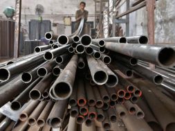 A worker stacks steel pipes in the western Indian city of Ahmedabad