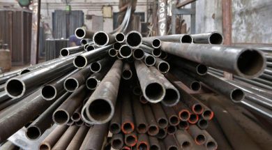 A worker stacks steel pipes in the western Indian city of Ahmedabad