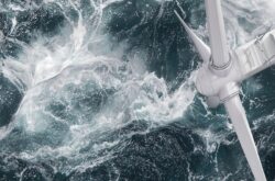 Aerial panorama of a close up wind turbine in the sea